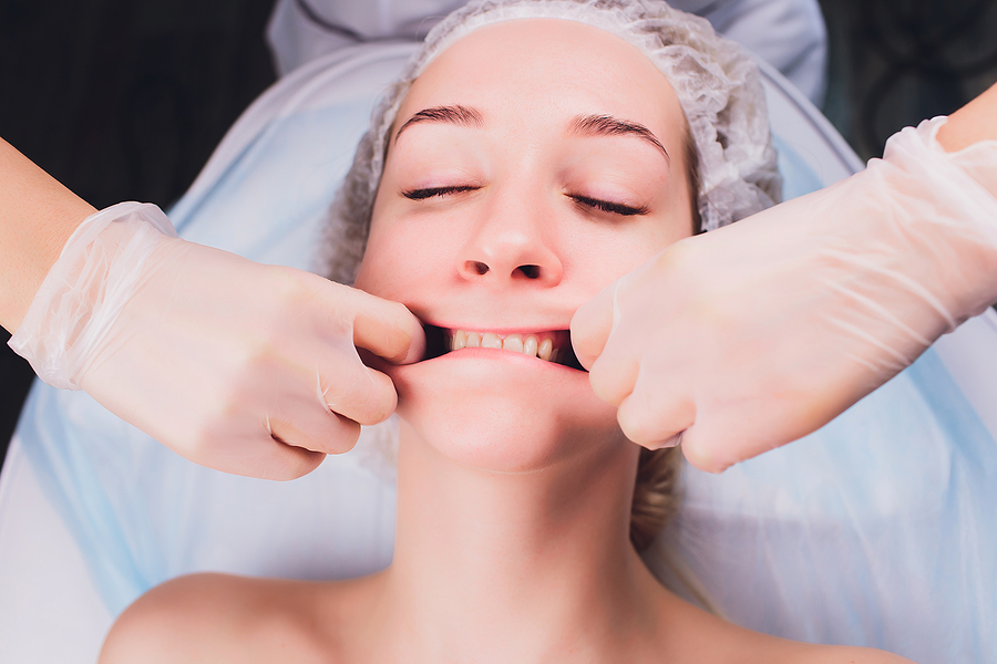 Zena praktizujuca masaz tvare pri bruxizme