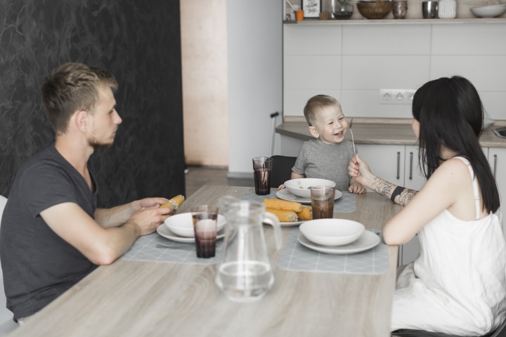 Rodina ranajkuje pri stole s malym babatkom