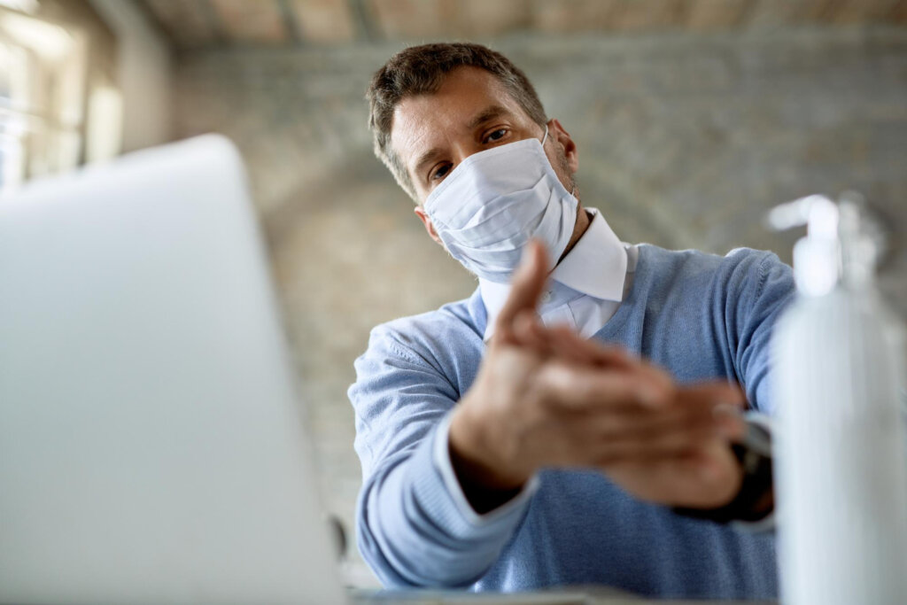 Muž si dezinfikuje ruky ako prevenciu pred zápalom priedušiek