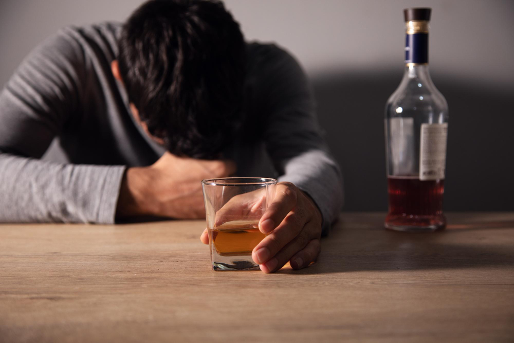 Muž ležiaci na stole s úzkosťou kvôli alkoholu