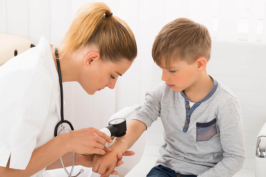 Dermatológ vyšetruje príznaky svrabu u dieťaťa